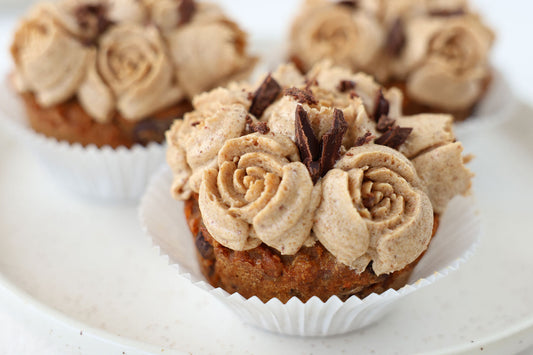 Karotten-Cupcakes mit einer  aufgespritzten Buttercreme und Schokoladensplittern