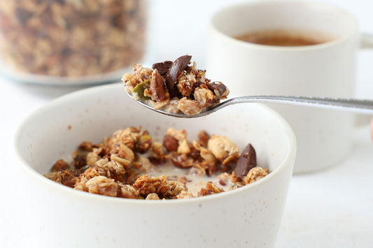 Granola mit Nüssen Schokostückchen auf einem Löffel