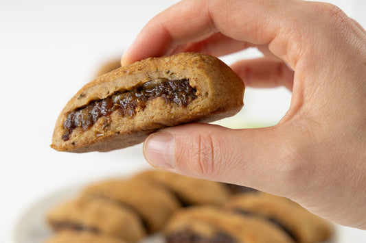 Vegane maltesische Imqaret - eine traditionelle Dattelschnitte in einer Hand gehalten
