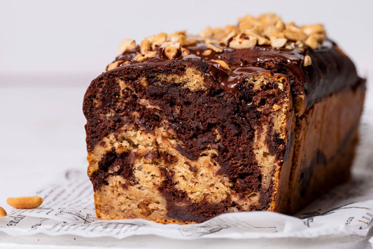 Angeschnittenes Schoko-Erdnuss-Bananenbrot mit Marmoreffekt und Schokoguss